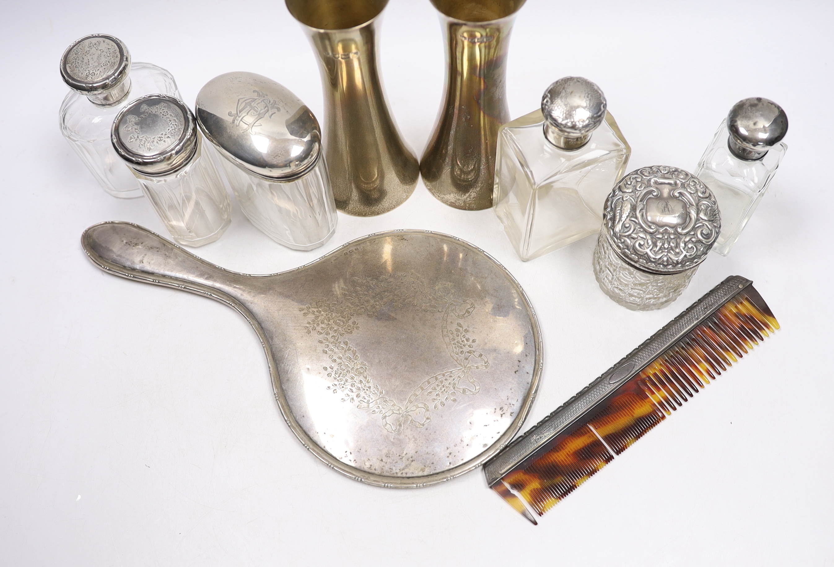 A pair of Edwardian silver waisted spill vase, London, 1907, 15cm, six silver mounted glass toilet jars, a silver mounted hand mirror and comb.